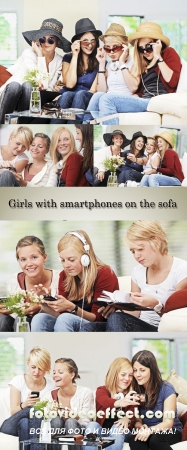 Stock Photo: 4 girls with smartphones on the sofa