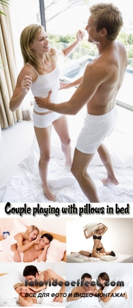 Stock Photo: Couple playing with pillows in bed