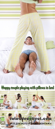 Stock Photo: Happy couple playing with pillows in bed